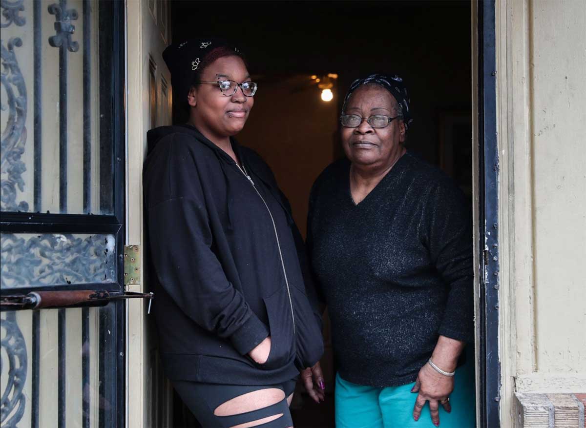 Daniya and her grandmother at front door of their home