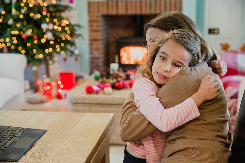 sad young girl at Christmas hugging her mother