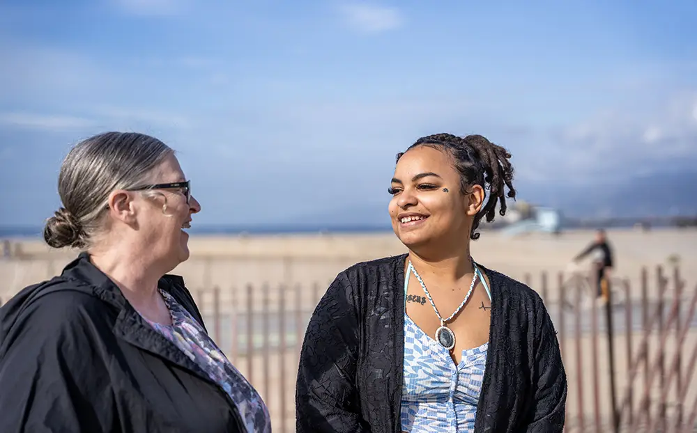 Tyra and her specialist talking and smiling at the beach