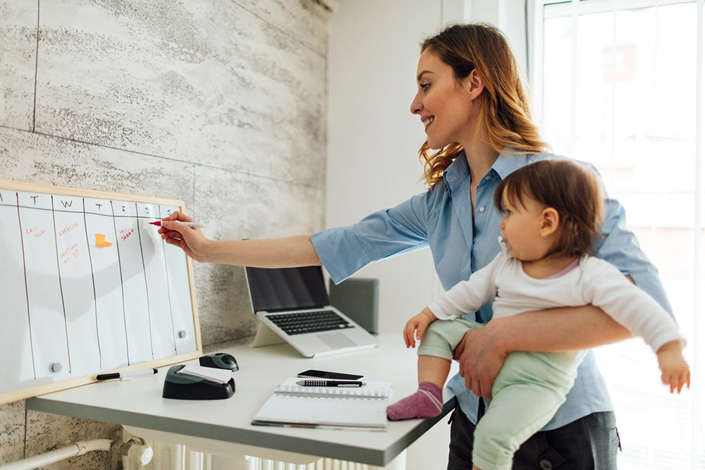 mother carrying child while working