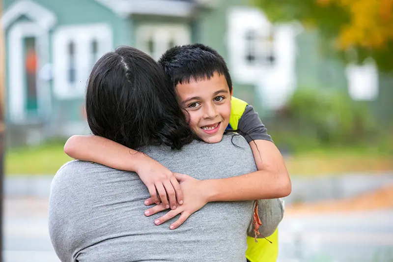 young boy hugging his mother