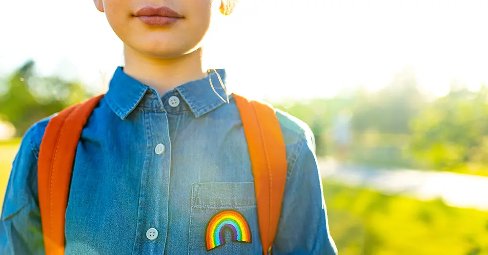 kid wearing backpack with rainbow patch