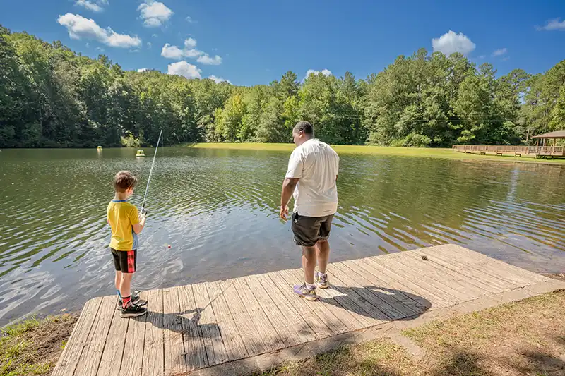 adult teaching young boy how to fish